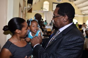 Hon. Eugene Hamilton greets mother and child  