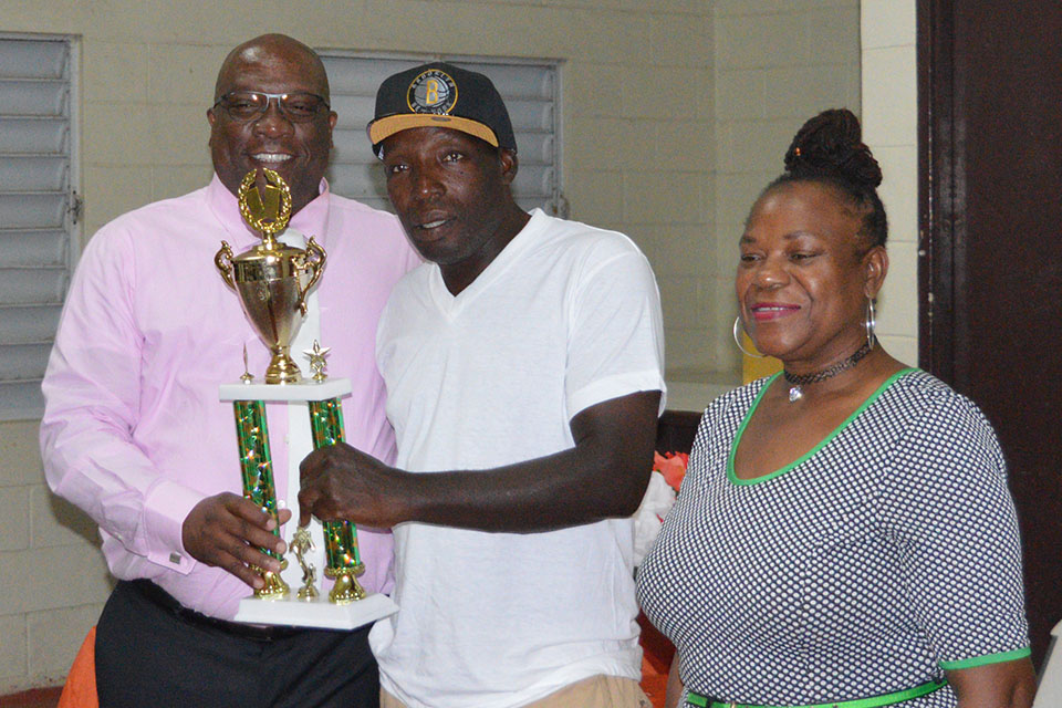 Prime Minister Harris presents trophy to the captain of the Unity domino team