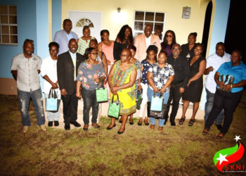 Back Row - Minister Hamilton (Left) and Prime Minister, Dr. the Honourable Timothy Harris (3rd right) along with NHC officials and new homeowners.